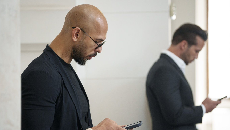 Andrew Tate, left, and his brother Tristan, right, wait inside the Court of Appeals building in Bucharest, Romania, Thursday, May 30, 2024. (AP Photo/Andreea Alexandru)