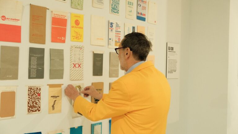 Eli Cox tends to a portion of his barf bag collection, which was displayed this spring in a New York exhibit by Dramamine called 'The Last Barf Bag.' (Dramamine via CNN Newsource)