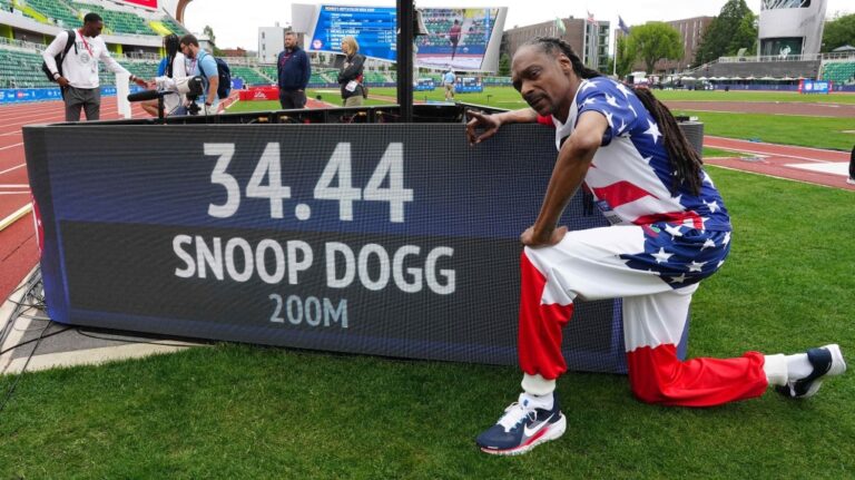 Snoop Dogg poses with his time after running the 200m in a guest appearance at the U.S. Olympic trials. (Kirby Lee / USA TODAY Sports / Reuters via CNN Newsource)