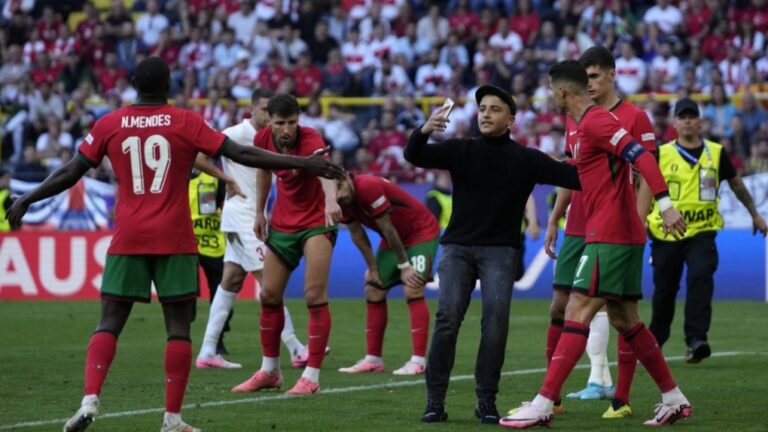 A pitch invader tries to take a selfie with Portugal's Cristiano Ronaldo during a Group F match between Turkey and Portugal at the Euro 2024 soccer tournament in Dortmund, Germany, Saturday, June 22, 2024. (AP Photo/Themba Hadebe)