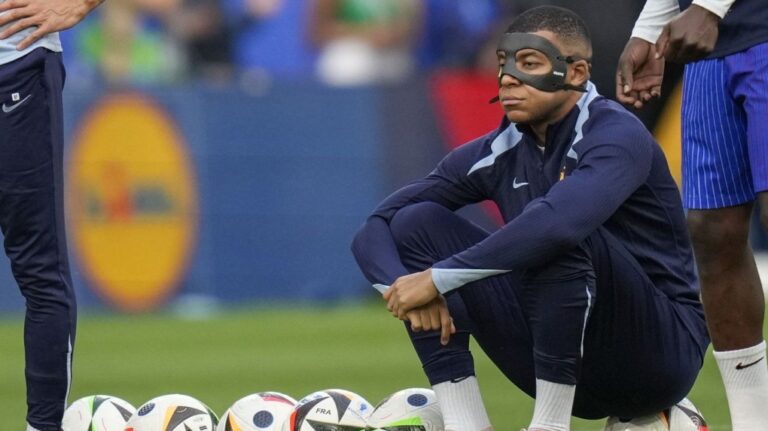 France's Kylian Mbappe with face mask during the warm up before a Group D match between the Netherlands and France at the Euro 2024 soccer tournament in Leipzig, Germany, Friday, June 21, 2024. (AP Photo/Ariel Schalit)