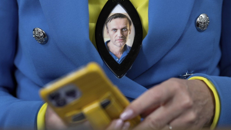 A woman wears a photograph of deceased Russian opposition leader Alexei Navalny during a service in St. Mary's Church on the occasion of his birthday, in Berlin, Tuesday, June 4, 2024. THE CANADIAN PRESS/AP-dpa, Christoph Gollnow