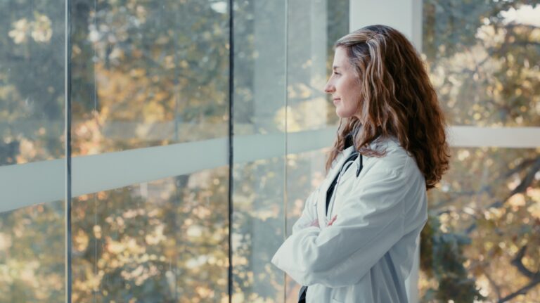 A health-care professional looks out a hospital window. (Getty Images / Kobus Louw)