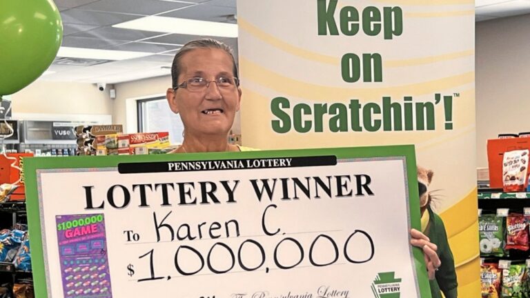 Freeport resident and US$1 million Pennsylvania Lottery winner Karen Coffman celebrates her win holding a commemorative lottery check at the BP gas station in Freeport, Pa., on Thursday, June 13, 2024. (Joyce Hanz/Pittsburgh Tribune-Review via AP)