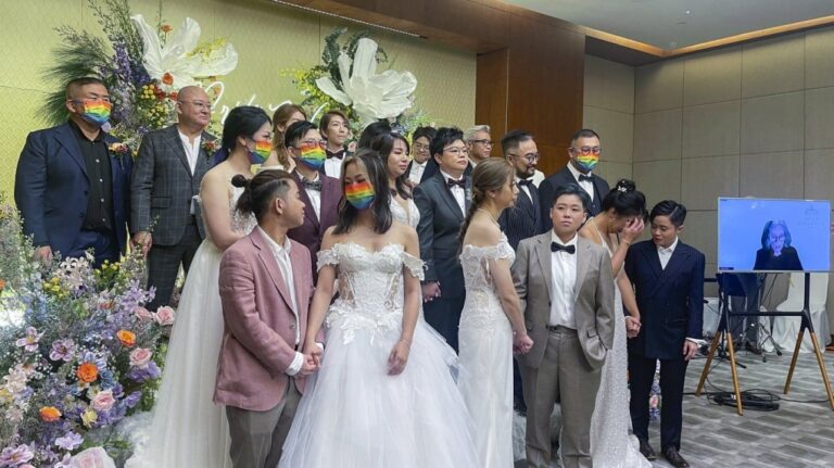 Ten same-sex couples who got married in the United States over the internet stand during their wedding at Eaton Hotel, Kowloon, Hong Kong, Tuesday, June 25, 2024. (AP Photo/Alice Fung)