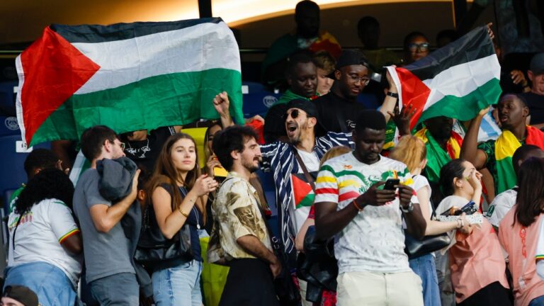 Spectators hold Palestinian flags as they watch the men's group D match between Israel and Mali at the Parc des Princes during the 2024 Summer Olympics, Wednesday, July 24, 2024, in Paris, France. (AP Photo/Aurelien Morissard)