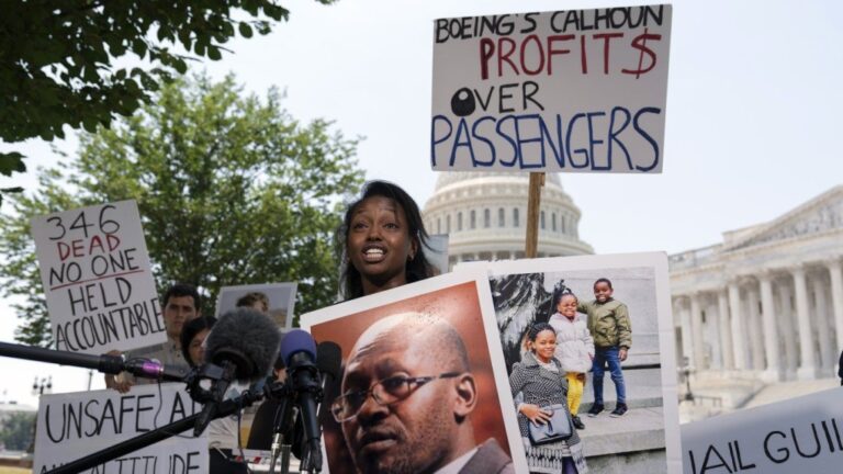 Zipporah Kuria of England, lost her father Joseph Kuria, one of the crash victims of a Boeing 737 MAX8 in Ethiopia, holds his photographs as she speaks during a news conference on Capitol Hill, Tuesday, June 18, 2024, in Washington. ( AP Photo/Jose Luis Magana)