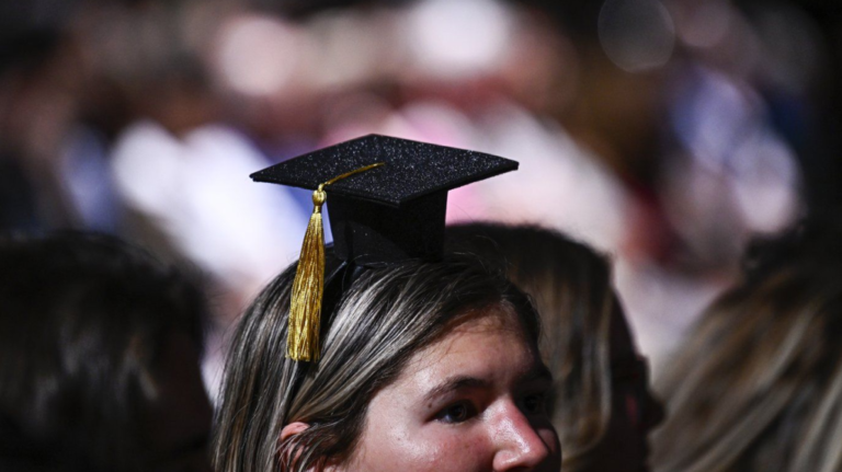 A bachelors of science graduate wears a headband featuring a miniature mortarboard cap as they attend their University of Ottawa convocation ceremony in Ottawa, on Saturday, June 10, 2023. THE CANADIAN PRESS/Justin Tang