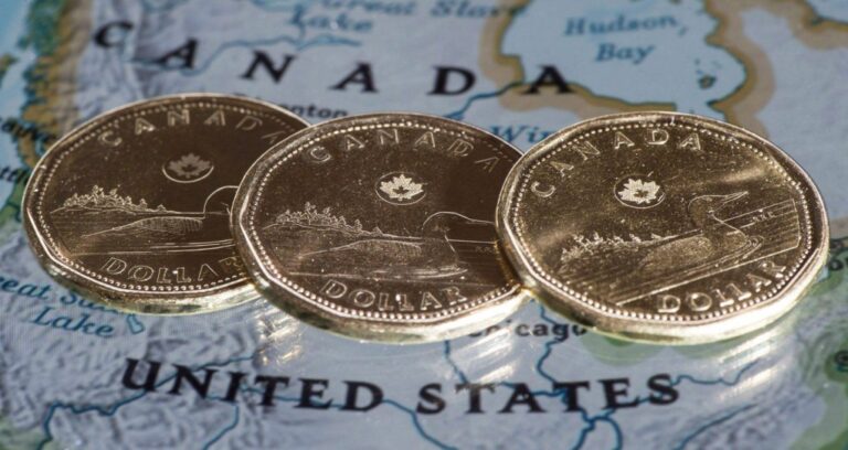 Canadian dollar coins are displayed on a map along the border of Canada and the United States of America, in Montreal in a January 9, 2014. (Paul Chiasson/Canadian Press)
