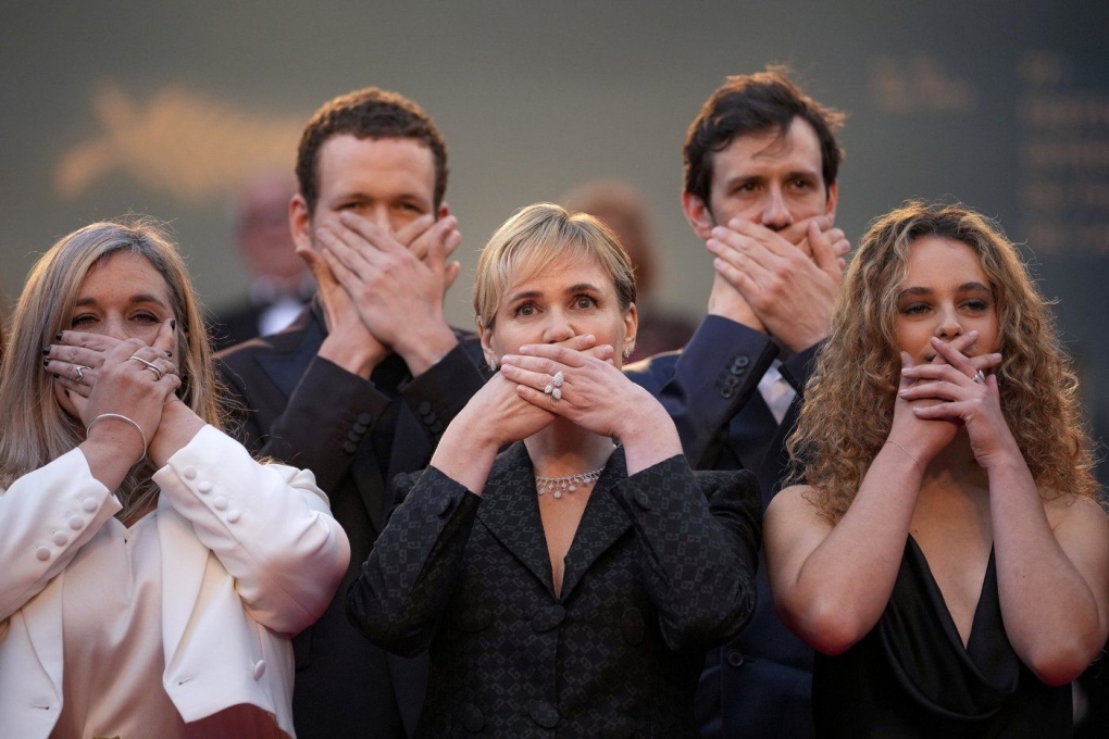 Judith Godreche, center, poses with hands covering their mouth upon arrival at the premiere of the film 'Furiosa: A Mad Max Saga' at the 77th international film festival, Cannes, southern France, Wednesday, May 15, 2024.  (Photo by Andreea Alexandru/Invision/AP, File)