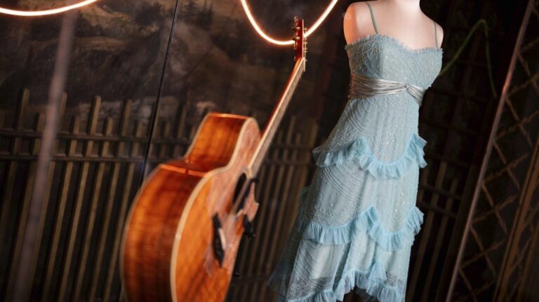 A guitar and stage costume from previous concert tours are displayed at the 'Taylor Swift Songbook Trail Exhibition' at the Victoria & Albert Museum, on Wednesday, July 24, 2024 in London. (Scott A Garfitt/Invision/AP)