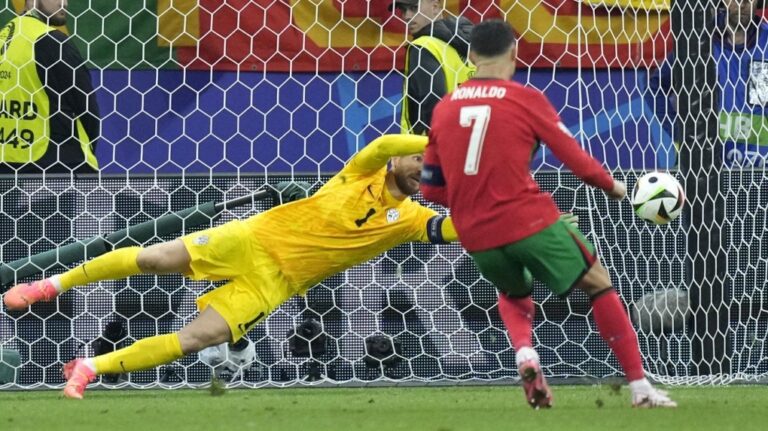 Slovenia's goalkeeper Jan Oblak blocks a penalty kick by Portugal's Cristiano Ronaldo (7) during a round of sixteen match at the Euro 2024 soccer tournament in Frankfurt, Germany, Monday, July 1, 2024. (Ebrahim Noroozi/AP Photo)