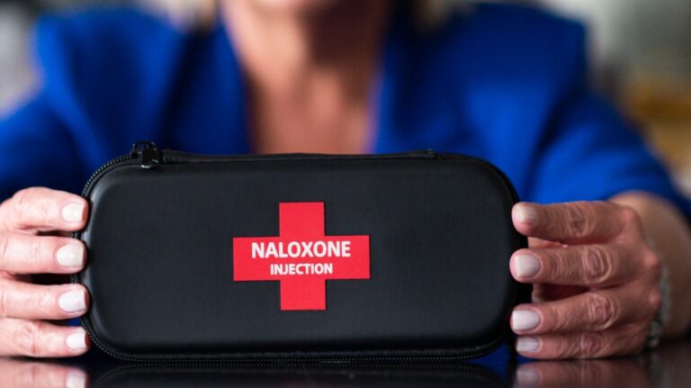 Jenny Churchill holds a naloxone kit at her kitchen table at her home in Regina, on Friday July 12, 2019. THE CANADIAN PRESS/Michael Bell