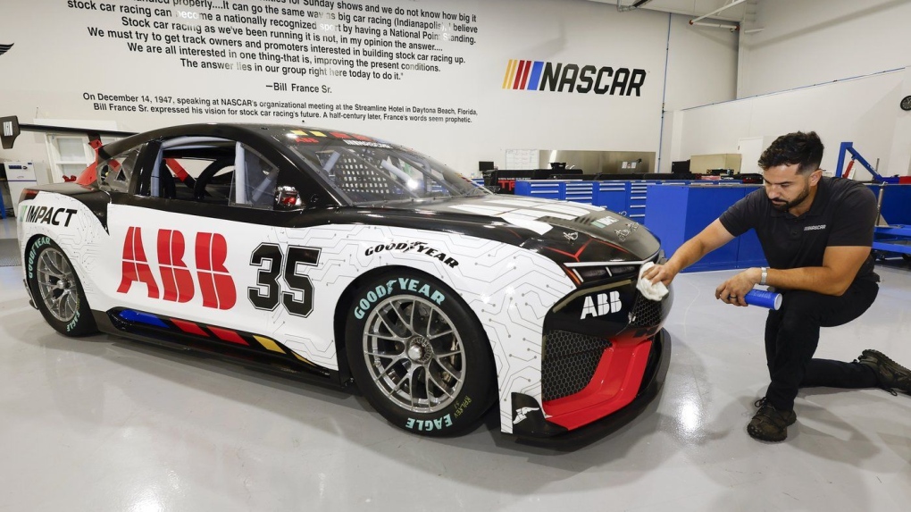 CJ Tobin, senior engineer of vehicle systems, cleans a prototype of the first electric racecar at the NASCAR R&D Center in Concord, N.C., Monday, July 1, 2024. (AP Photo/Nell Redmond)