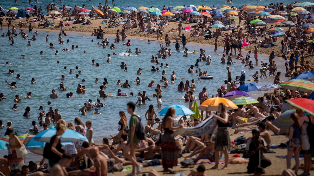 People cool off in the water on a hot and sunny day at the beach in Barcelona, Spain, July 15, 2022. (Emilio Morenatti / AP Photo, File)