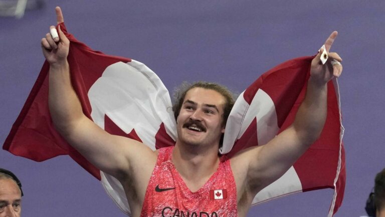 Ethan Katzberg, of Nanaimo, B.C., celebrates after winning gold in the men's hammer throw event at the 2024 Summer Olympics, Sunday, Aug. 4, 2024, in Saint-Denis, France. THE CANADIAN PRESS/Adrian Wyld