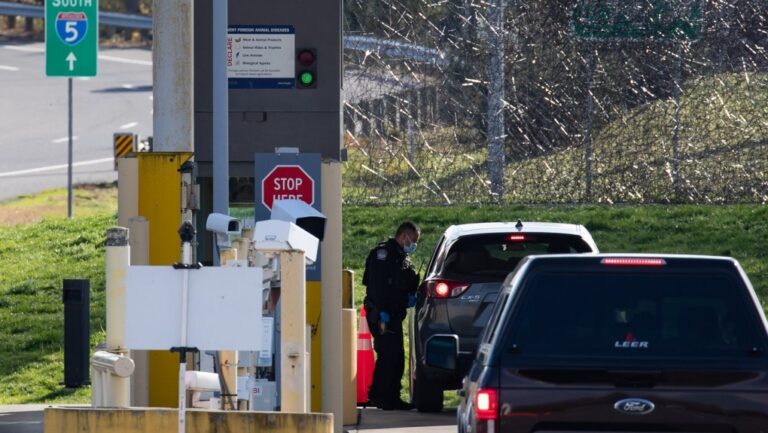 A U.S. Customs and Border Protection officer speaks to a British Columbia motorist at the Peace Arch border crossing in Blaine, Wash., across the Canada-U.S. border from Surrey, B.C. (Darryl Dyck/The Canadian Press)