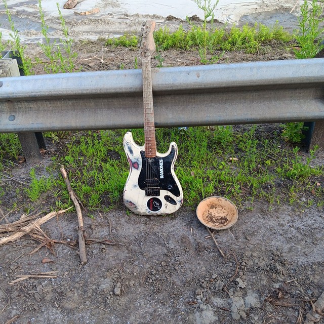 la guitare s'appuie contre le rail de l'autoroute.