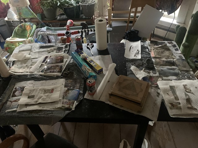 Une table est remplie de papiers dans divers états de conservation.