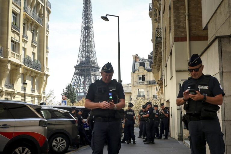 Police officers gather in a street near the Eiffel Tower on the eve of the Paralympic Games opening ceremony, Tuesday, Aug. 27, 2024 in Paris. (AP Photo/Thomas Padilla)