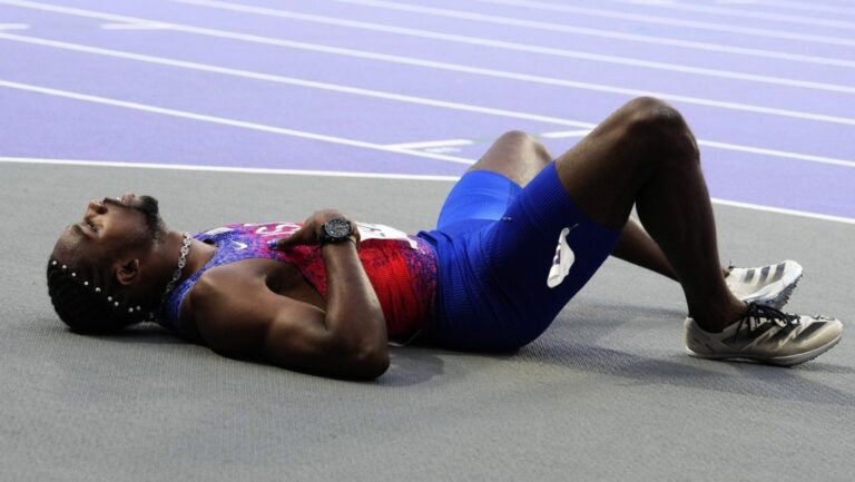Noah Lyles, of the United States, lies on the track following the men's 200-metres final at the 2024 Summer Olympics, Thursday, Aug. 8, 2024, in Saint-Denis, France. (AP Photo/Petr David Josek)