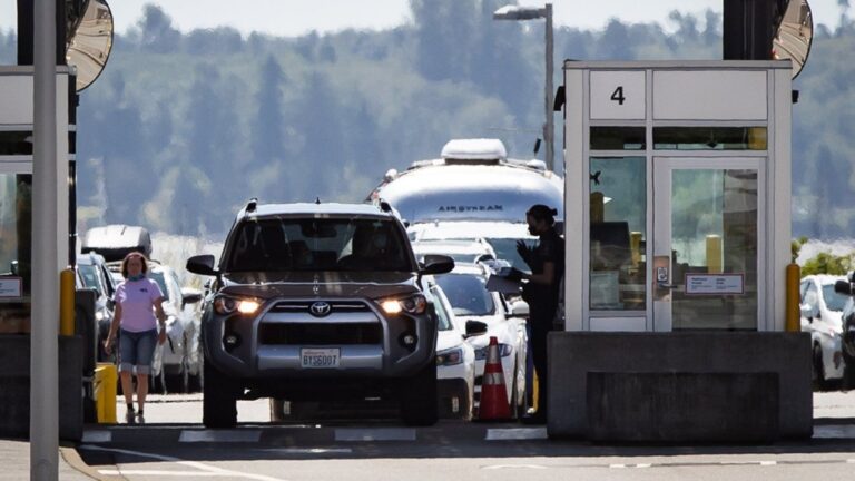 A Canada Border Services Agency officer speaks to a motorist entering Canada at the Douglas-Peace Arch border crossing, in Surrey, B.C., on Monday, August 9, 2021. THE CANADIAN PRESS/Darryl Dyck