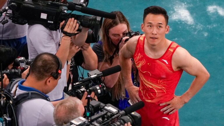Xiao Ruoteng, of China, reacts after seeing Shinnosuke Oka, of Japan, won the gold medal during the men's artistic gymnastics all-around finals in Bercy Arena at the 2024 Summer Olympics, Wednesday, July 31, 2024, in Paris, France. (AP Photo/Morry Gash)