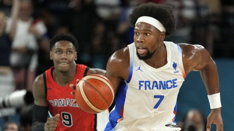 France's Guerschon Yabusele, right, drives the court followed by Canada's RJ Barrett during a men's quarterfinal game at the 2024 Summer Olympics on Aug. 6, 2024, in Paris, France. (Mark J. Terrill/The Canadian Press)