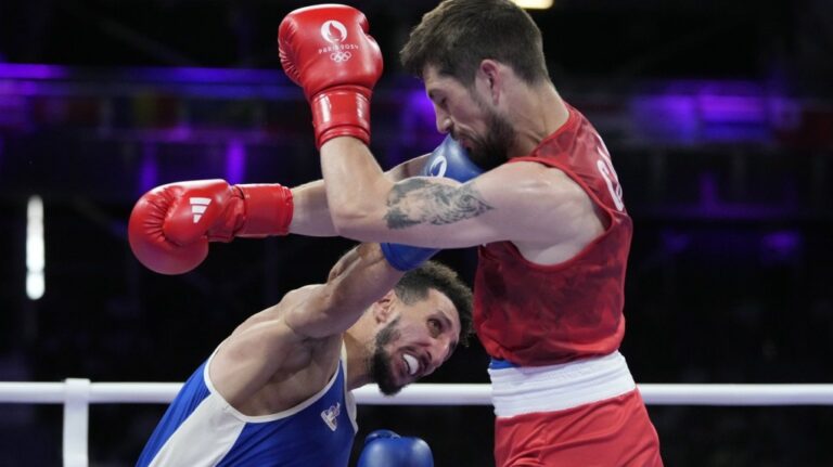 France's Sofiane Oumiha, left, punches Canada's Wyatt Sanford in their men's 63.5 kg semifinal boxing match at the 2024 Summer Olympics, Sunday, Aug. 4, 2024, in Paris, France. Sanford ended one streak and continued another on Day 9 of the Paris Olympics. (THE CANADIAN PRESS/AP Photo/Ariana Cubillos)