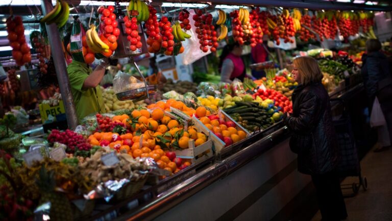 In this Thursday Jan. 17, 2013 file photo, a woman buys fruit at a market in Barcelona, Spain. (AP Photo/Emilio Morenatti)