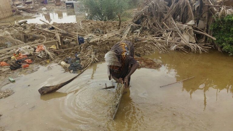 A woman sorts through floodwaters near her damaged home near the city of Abu Hamdan in Northern Sudan on Aug. 7, 2024. (AP Photo/ Samira Hassan)