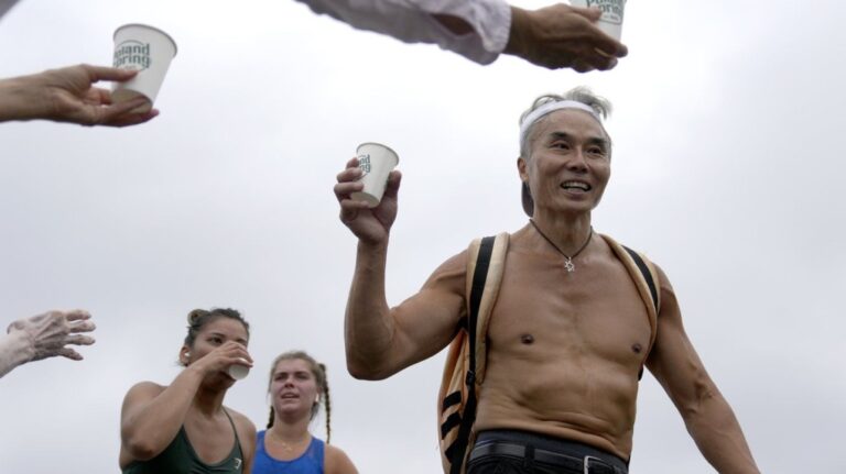 Runners grab water near the three-mile mark in the Falmouth Road Race, Sunday, Aug. 18, 2024, in Falmouth, Mass. (AP Photo/Jeff Roberson)