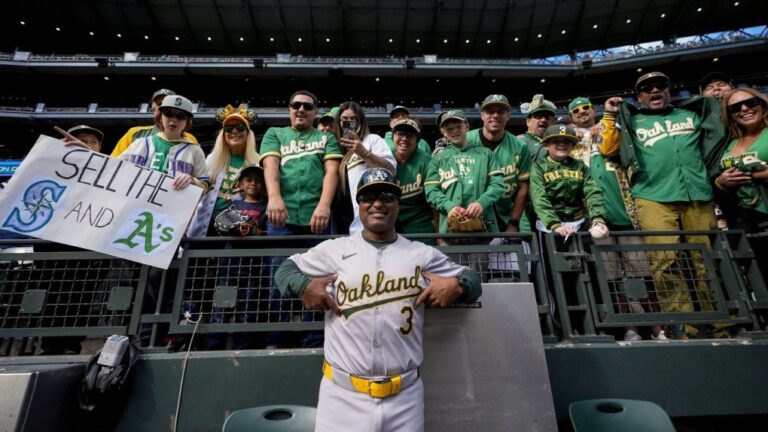 Oakland Athletics third base coach Eric Martins (3) poses with fans before a baseball game against the Seattle Mariners, Sunday, Sept. 29, 2024, in Seattle. (AP Photo/Lindsey Wasson)
