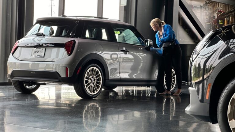 A prospective buyer looks over a 2025 Cooper S hardtop displayed at a Mini dealership on July 22, 2024, in Highlands Ranch, Colo. (AP Photo/David Zalubowski)