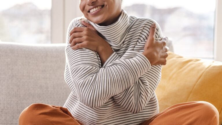 Self-compassionate touch, which can be practised anywhere, can include stroking the upper arms like a hug. (Milko/E+/Getty Images via CNN Newsource)