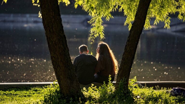 A couple sits by the lake in Cismigiu park, in Bucharest, Romania on April 24, 2024. (AP Photo/Vadim Ghirda, File)