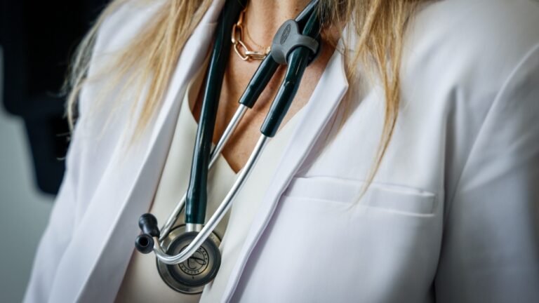 A doctor wears a lab coat and stethoscope in an exam room at a health clinic in Calgary, Alta., July 14, 2023. THE CANADIAN PRESS/Jeff McIntosh