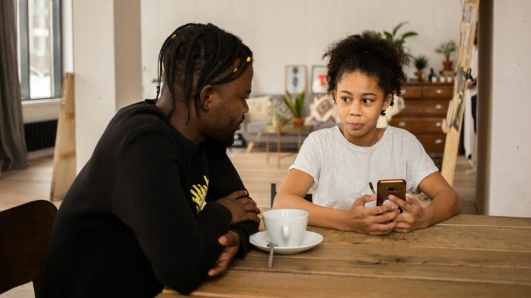 A father and daughter sit together at the dining table. (Monstera Production / Pexels)