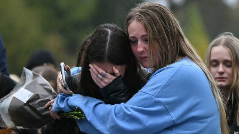 Fans comforting each other while paying tribute to Liam Payne at a memorial held on Sunday in London's Hyde Park.
