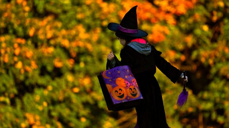 A child leaves after receiving free Halloween candy from a local businessman, Tuesday, Oct. 31, 2023, in Lewiston, Maine. (AP Photo/Matt York)