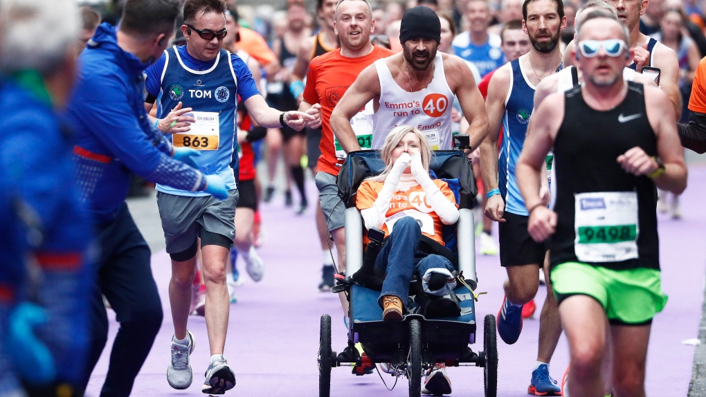 Actor Colin Farrell ran the final 4 kilometers of the Irish Life Dublin Marathon 2024 while pushing close friend Emma Fogarty. (Peter Morrison / AP via CNN Newsource)