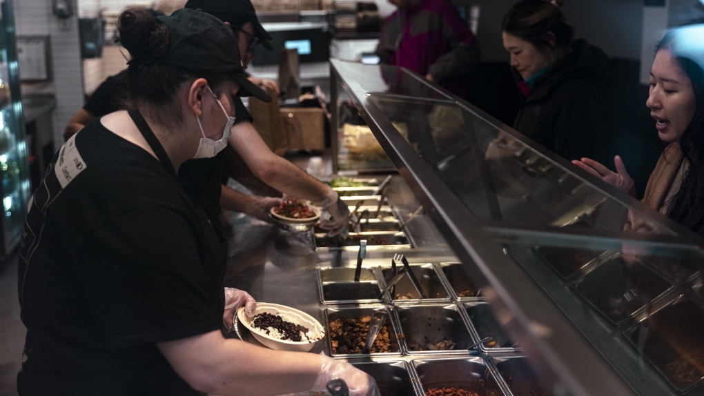 Workers serve food inside a Chipotle restaurant in New York on January 12, 2024. (Angus Mordant / Bloomberg / Getty Images / File via CNN Newsource)