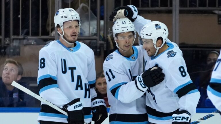 Utah Hockey Club's Mikhail Sergachev, left, Dylan Guenther, center, and Nick Schmaltz, right, celebrate after Guenther scored during the second period of an NHL hockey game against the New York Rangers, Saturday, Oct. 12, 2024, in New York. (AP Photo/Pamela Smith)