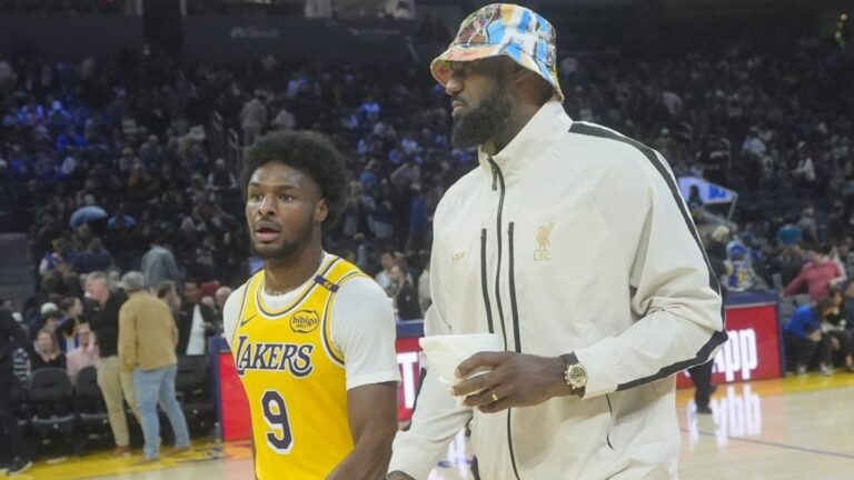 Los Angeles Lakers guard Bronny James walks off the floor with forward LeBron James during halftime of an NBA preseason basketball game against the Golden State Warriors on Friday, Oct. 18, 2024. (AP Photo/Jeff Chiu)