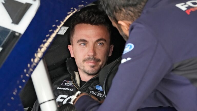 Race car driver and actor Frankie Muniz talks to a crew member at Daytona International Speedway in Daytona Beach, Fla., on Feb. 16, 2024. (Chris O'Meara / AP Photo)