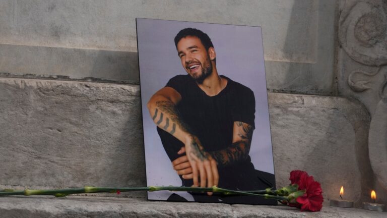A photo of former One Direction singer Liam Payne is placed with a rose and candles as fans gather in Madrid, Spain, Sunday, Oct. 20, 2024. (AP Photo/Paul White)