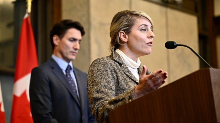 Minister of Foreign Affairs Melanie Joly speaks as Prime Minister Justin Trudeau listens during a news conference on the investigative efforts related to violent criminal activity occurring in Canada with connections to India, on Parliament Hill in Ottawa, on Monday, Oct. 14, 2024. (THE CANADIAN PRESS/Justin Tang)