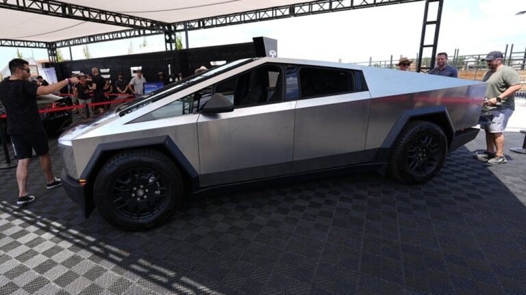 Visitors look over a 2024 Cybertruck in the Tesla display at the Electrify Expo, July 14, 2024, in north Denver. (AP Photo/David Zalubowski, File)