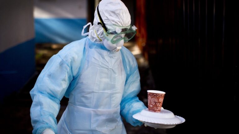 In this Oct. 8, 2014 photo, a medical worker from the Infection Prevention and Control unit wearing full protective equipment carries a meal to an isolation tent  at the Kenyatta National Hospital in Nairobi, Kenya. (AP Photo/Ben Curtis, File)
