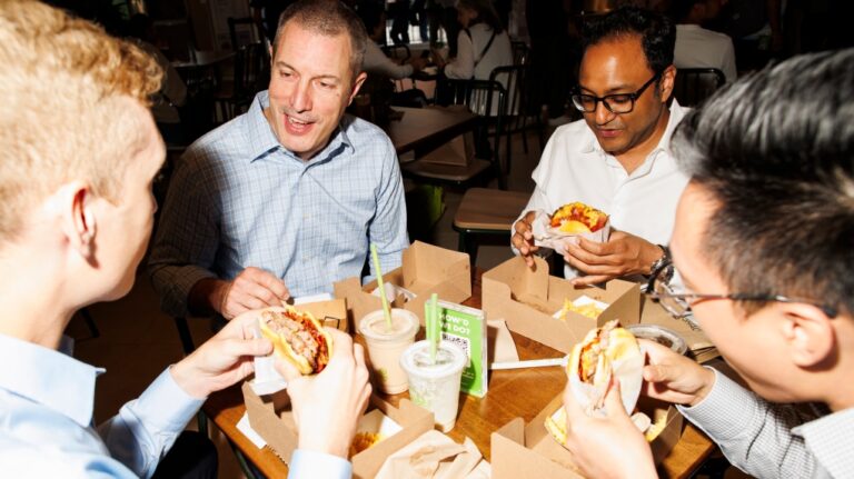 Some of the first customers of the newly opened Shake Shack eat their meals at the restaurant in Toronto, Thursday, June 13, 2024. THE CANADIAN PRESS/Cole Burston